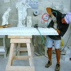 a stonecutter chiseling the pediment of a fireplace Frilli Gallery Marble Studio